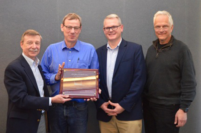 Jefferson Lab Deputy Director Robert McKeown (left) presents a plaque commemorating the first observation of charm quarks at J-Lab to the GlueX Collaboration. Shown receiving the award (right to left) are Eugene Chudakov, J-Lab Hall Leader, Matthew Sheperd (IU), GlueX Deputy Spokesperson and Curtis Meyer (CMU) GlueX Spokesperson.