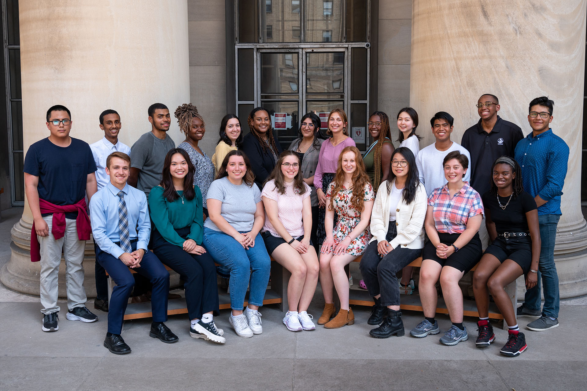 21 people sit near the Mellon Institute columns