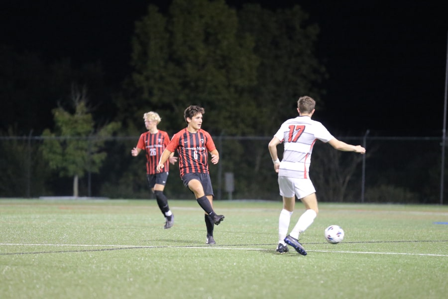 William Rabon plays soccer with one teammate and one opponent.