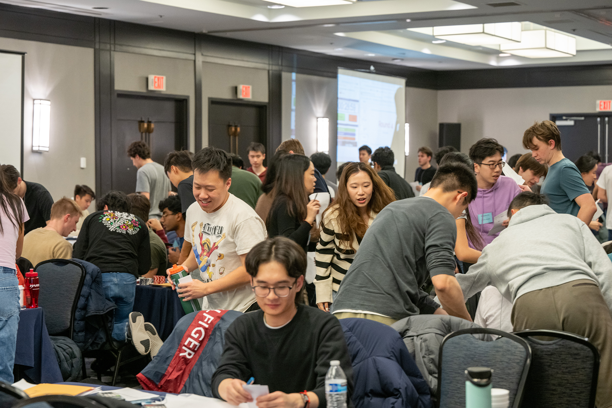 students rush around a hotel ballroom