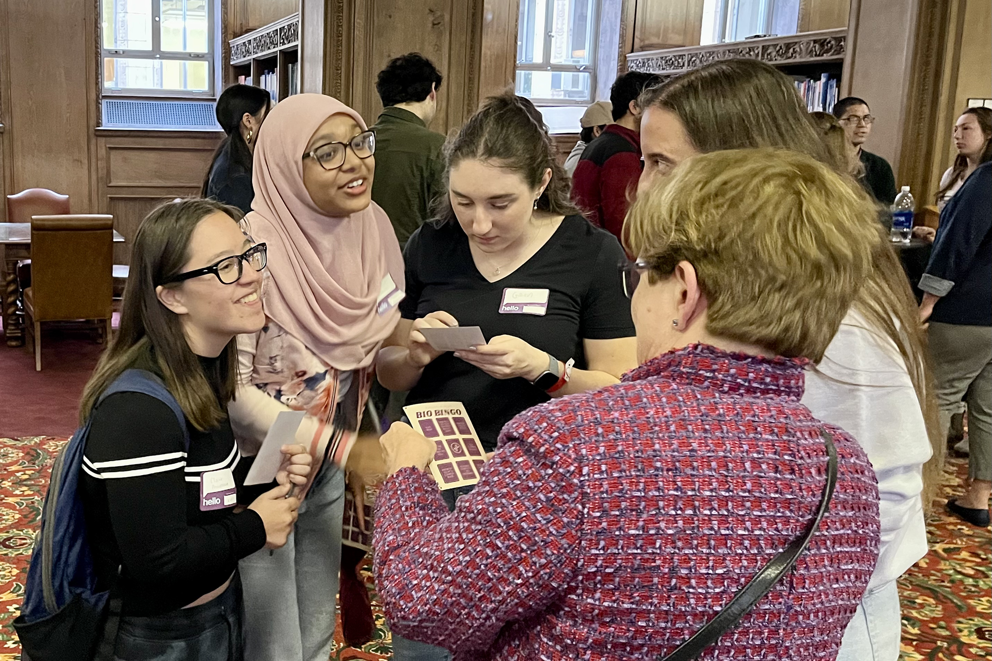 four students talk with a woman