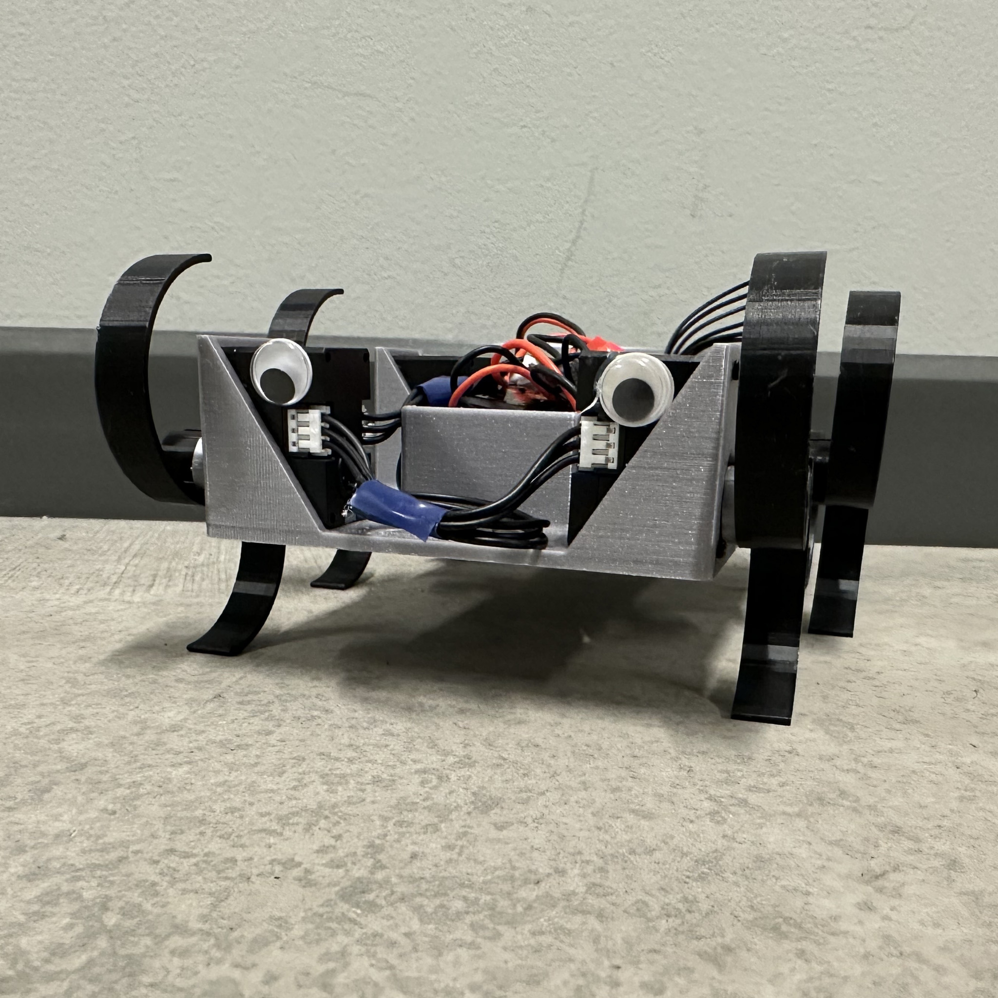 Front view image of MiniRhex robot standing on the floor.