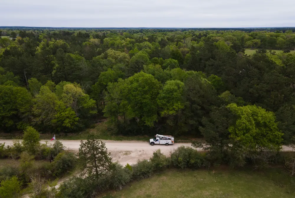 An aerial view of a utility truck parked on a gravel road