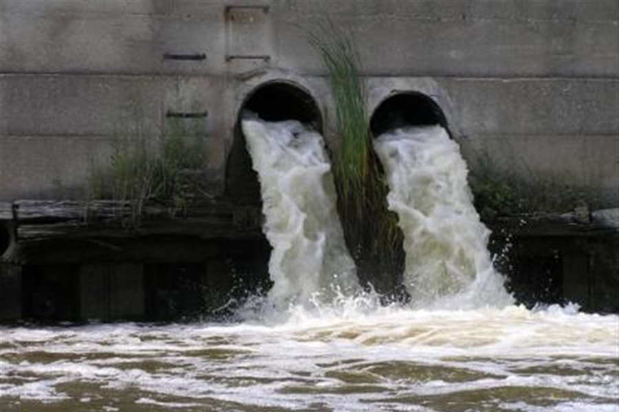 photo of water pouring out of stormwater drains into river