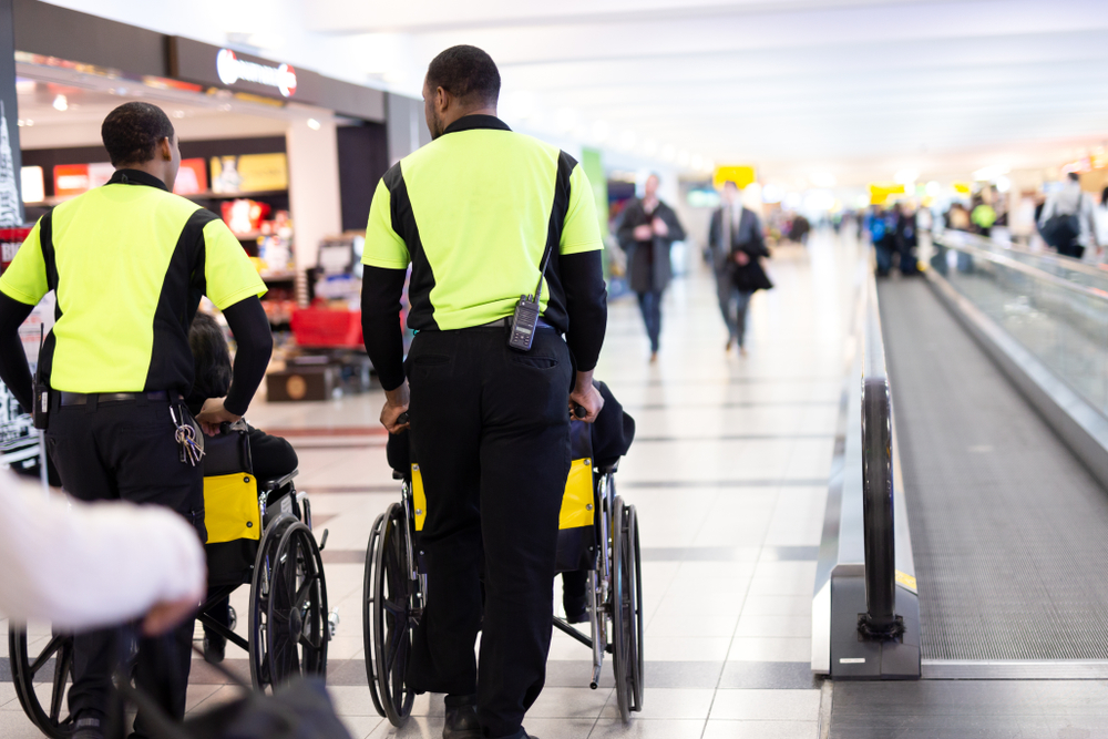 person pushing wheelchair at airport