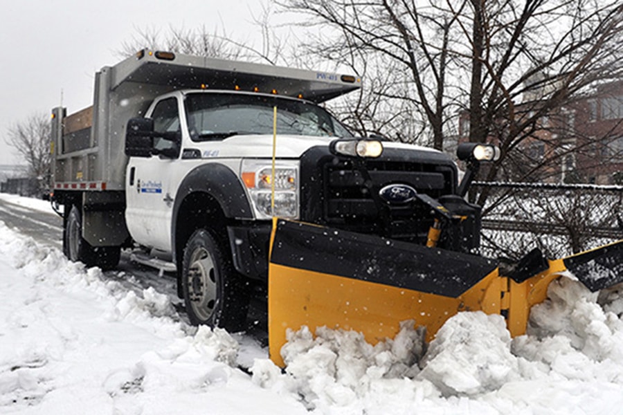 photo of truck plowing snow on a street