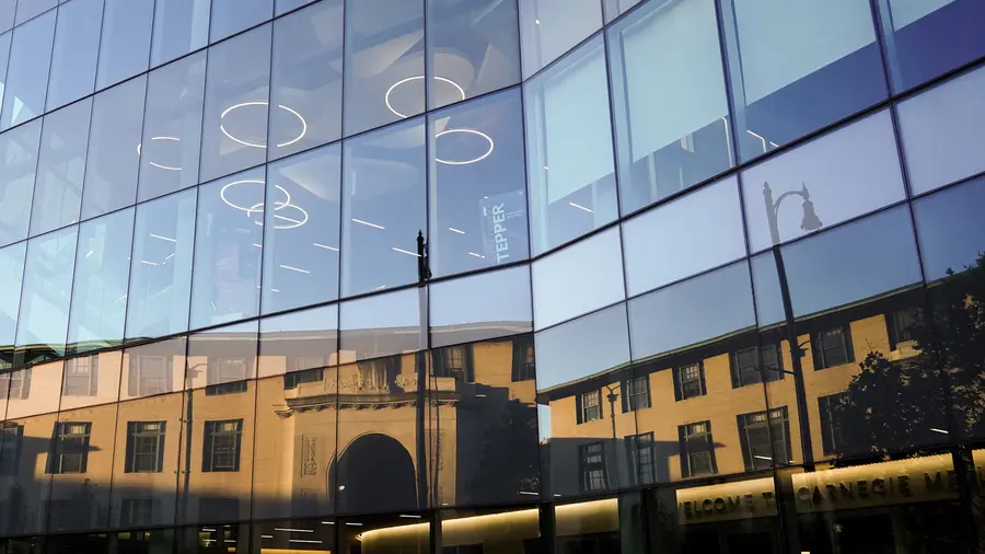 Hamburg Hall reflected in the Tepper Building's windows.