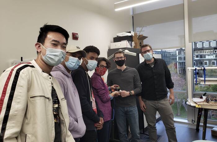 Group of masked students and staff in lab