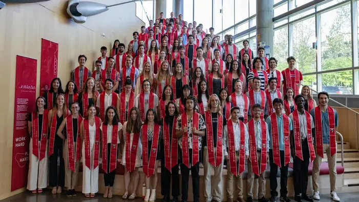 senior student-athletes pose wearing stoles inside Tepper Building