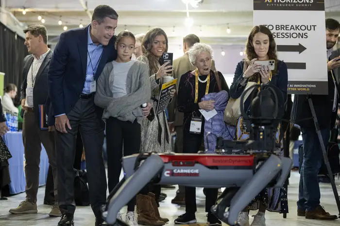 People looked at a four-legged robot. 