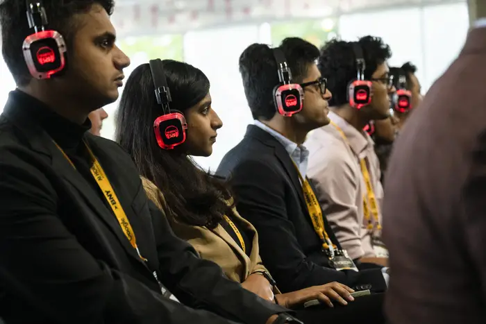 Attendees listen through headphones during a breakout session.
