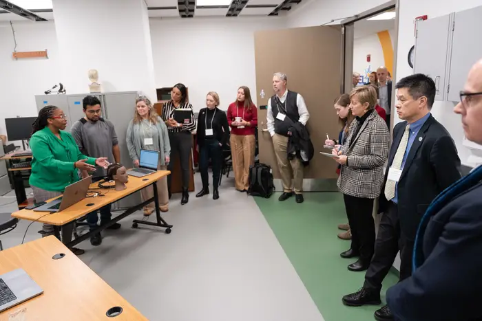 Sossena Wood (left), an assistant professor of biomedical engineering, demonstrates bias-free, noninvasive technologies used to measure brain activity and blood oxygenation and deliver deep-brain stimulation for the treatment of psychiatric conditions.