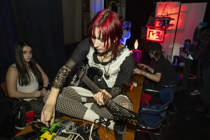 student seated with guitar