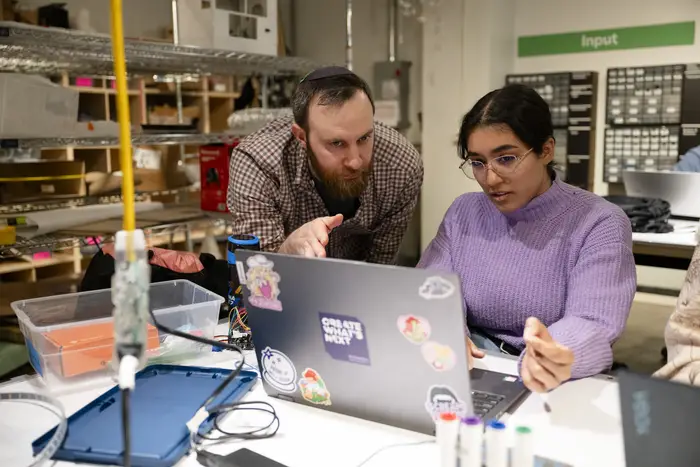 Robert Zacharias with student looking at laptop
