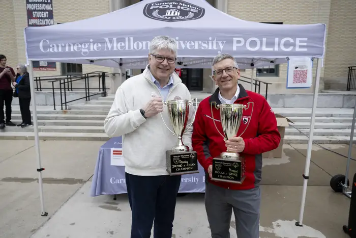 Bill Sanders and Jim Garrett hold trophies. 