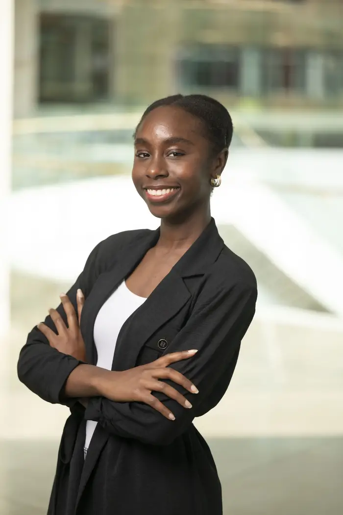 A woman with her arms crossed in front of her smiles