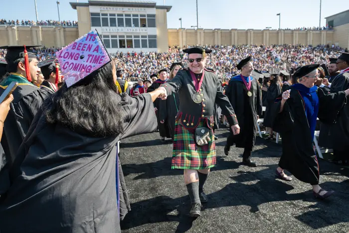 University Teaching Professor Mark Stehlik fist bumps a student.