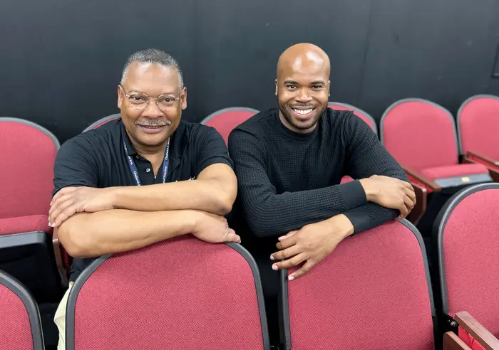 Robinson and Malcolm-Smith in a theater. 