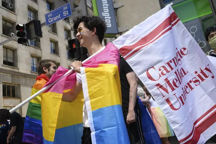 A marcher holds a CMU flag