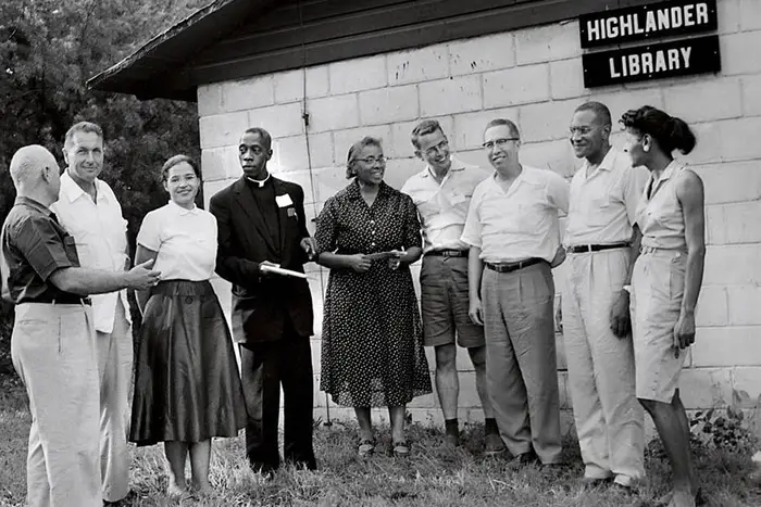 black and white image of Highlander participants and workshop leaders standing outside Highlander Library on the school's 25th anniversary in 1957