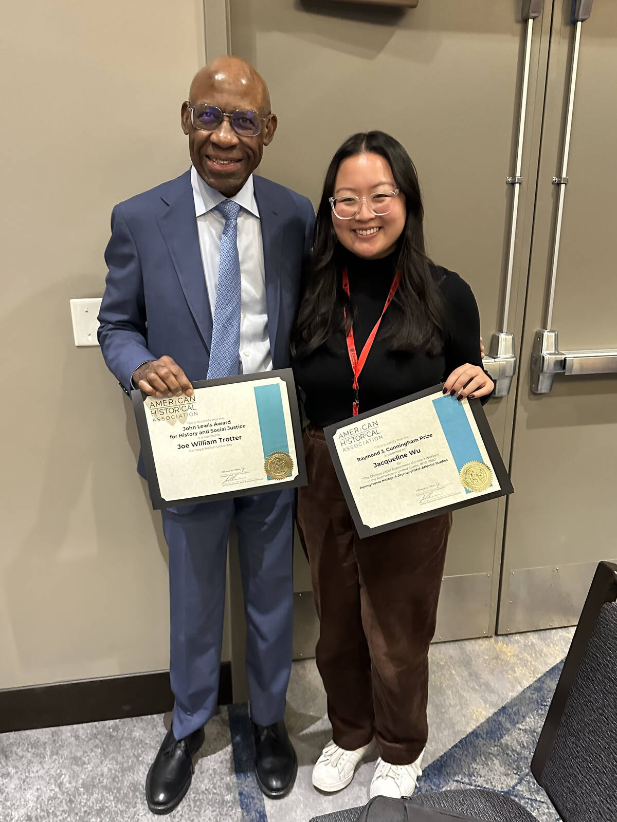 two people holding paper awards