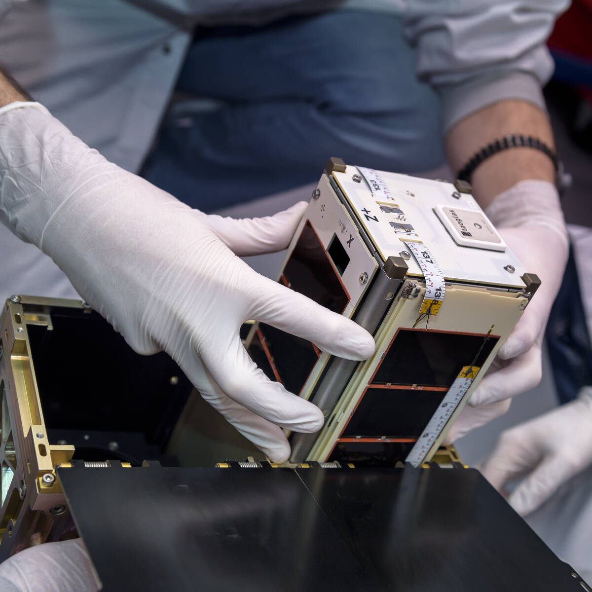 prepares one of the four PyCubed-Based CubeSat (PY4) spacecraft for installation into the Small Satellites Dispenser in the Small Spacecraft Technology (SST) lab.