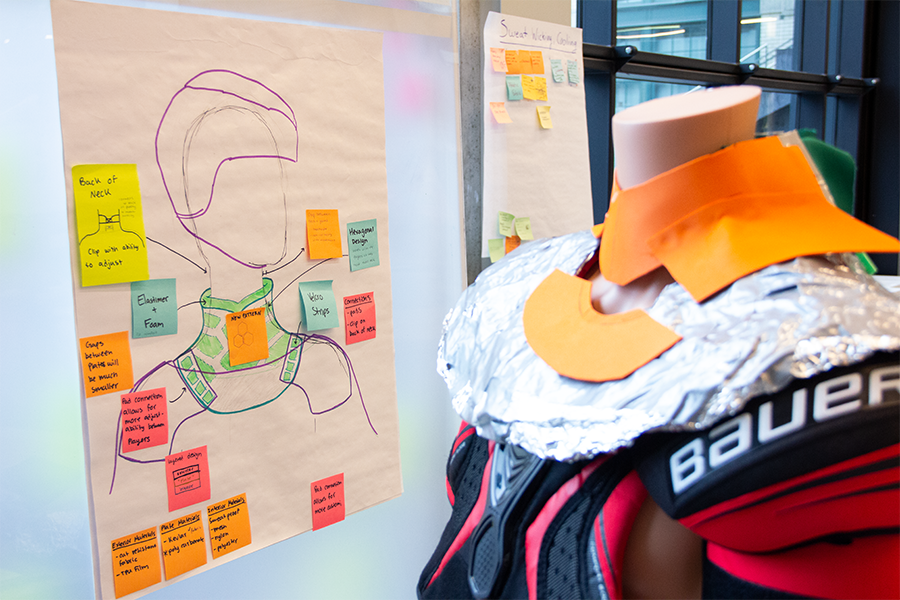mannequin showing neck protection idea next to white board with Post-it notes