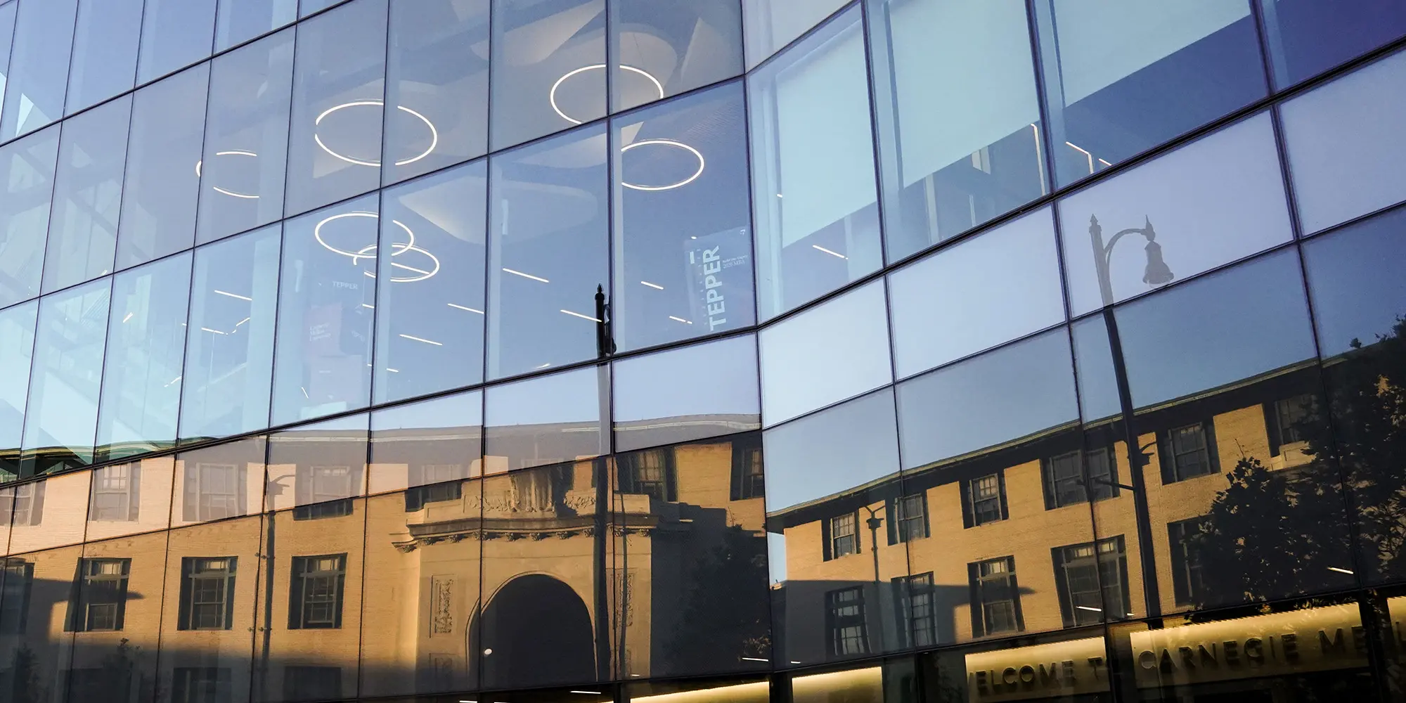 Hamburg Hall reflected in the Tepper Building's windows. 