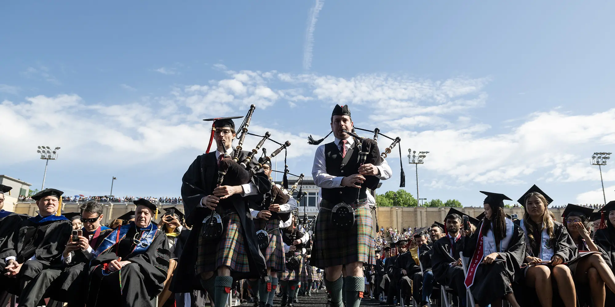 Bagpipers lead the procession.