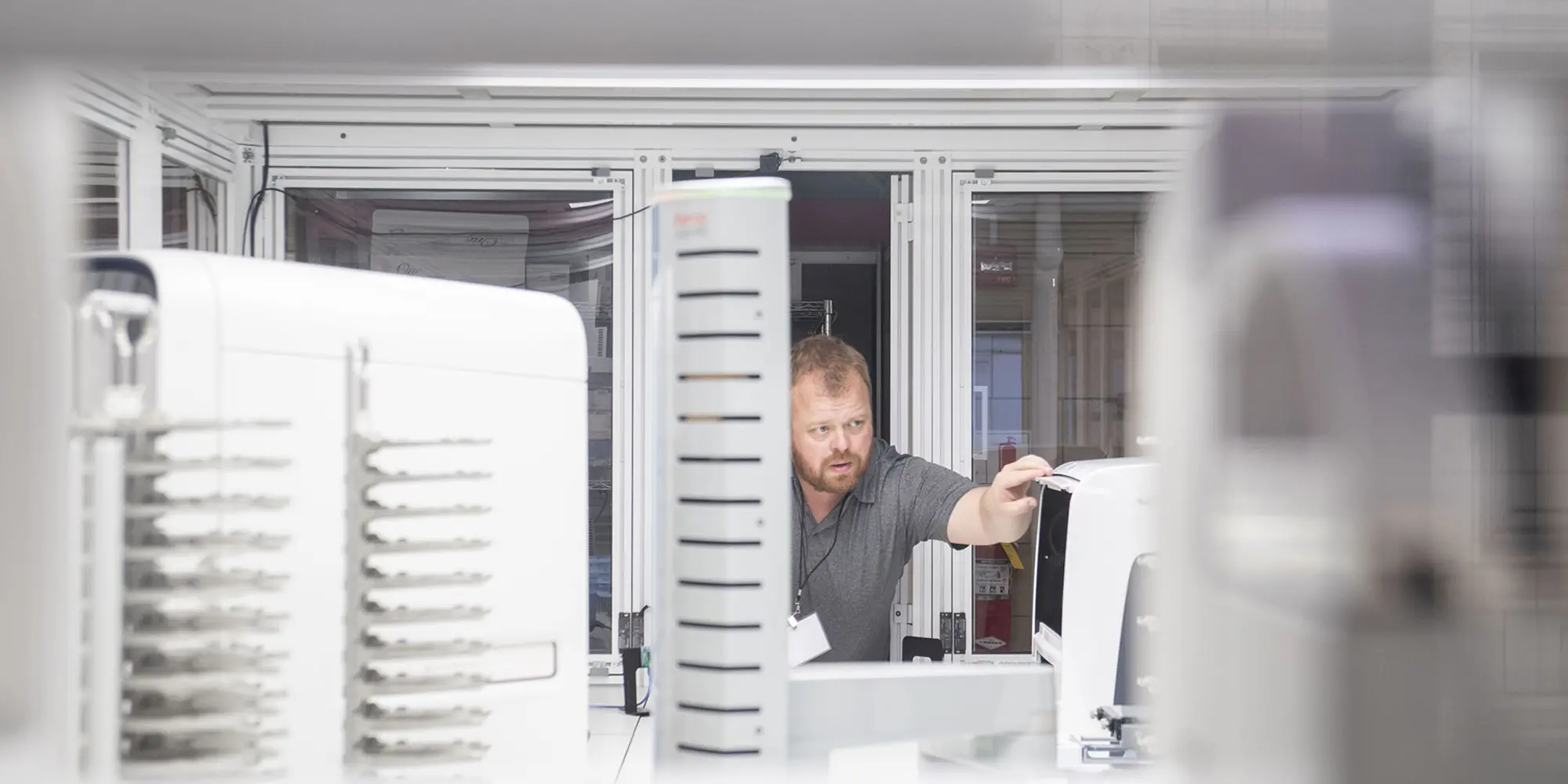 Computational Biology Assistant Professor Joshua Kangas checks a piece of equipment in the Automated Science Lab, where he conducted tours during the Nobel Turing Challenge Initiative Workshop.