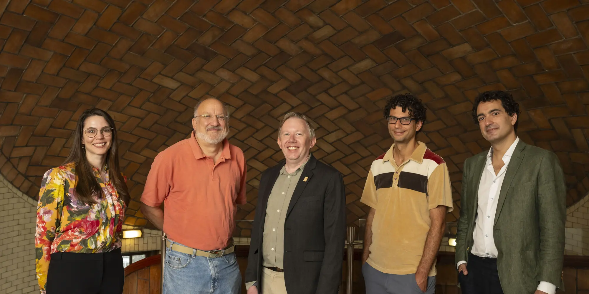 five people standing inside Baker Hall