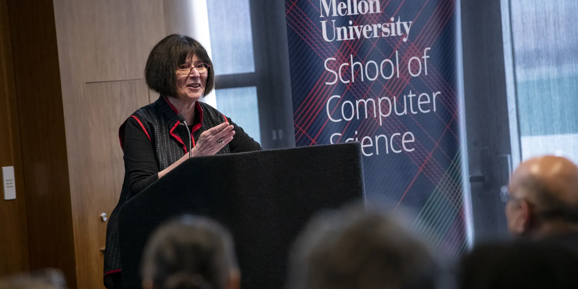 Lenore Blum standing at a podium.