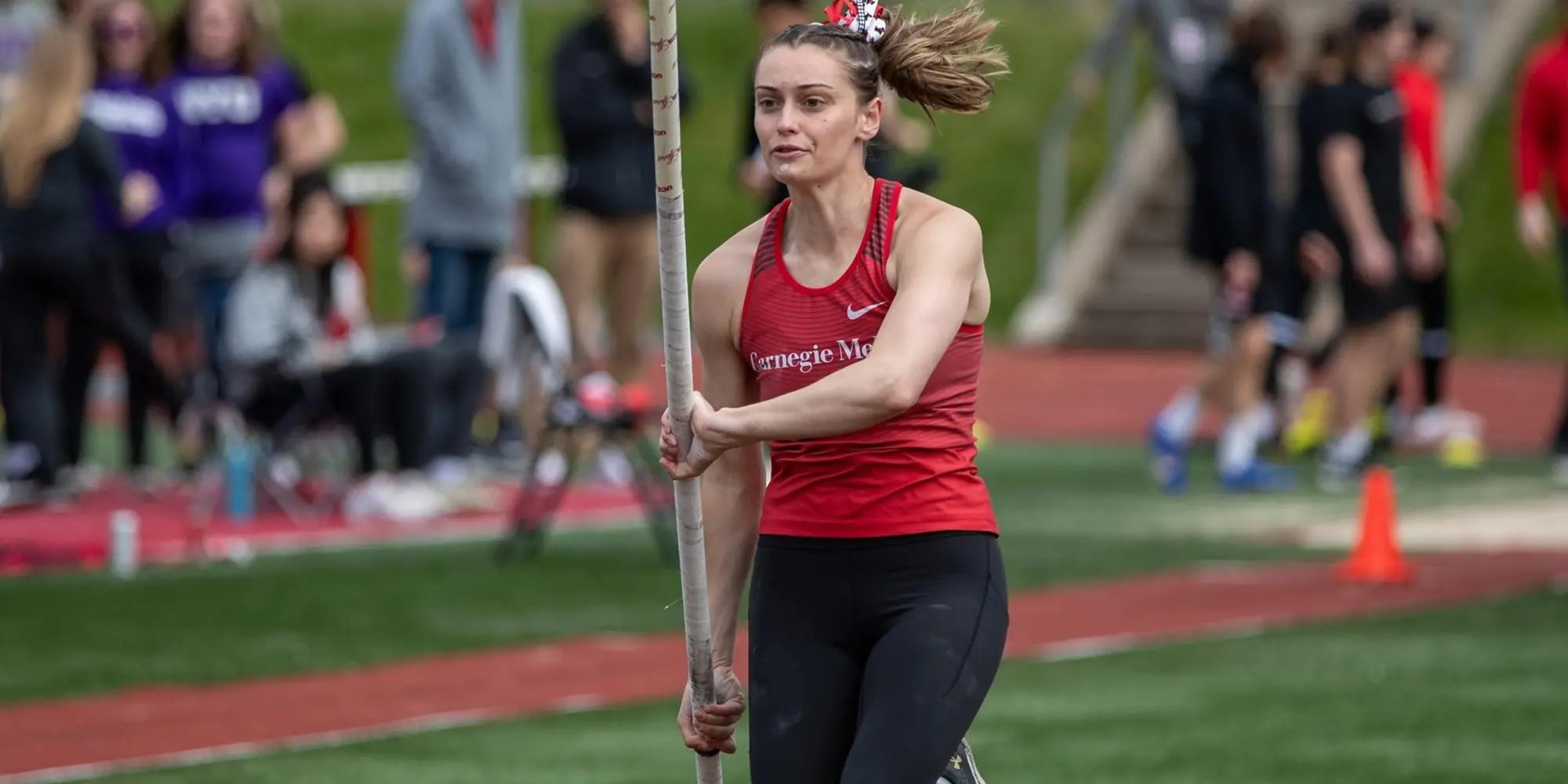 JoJo Huczko running with pole on field