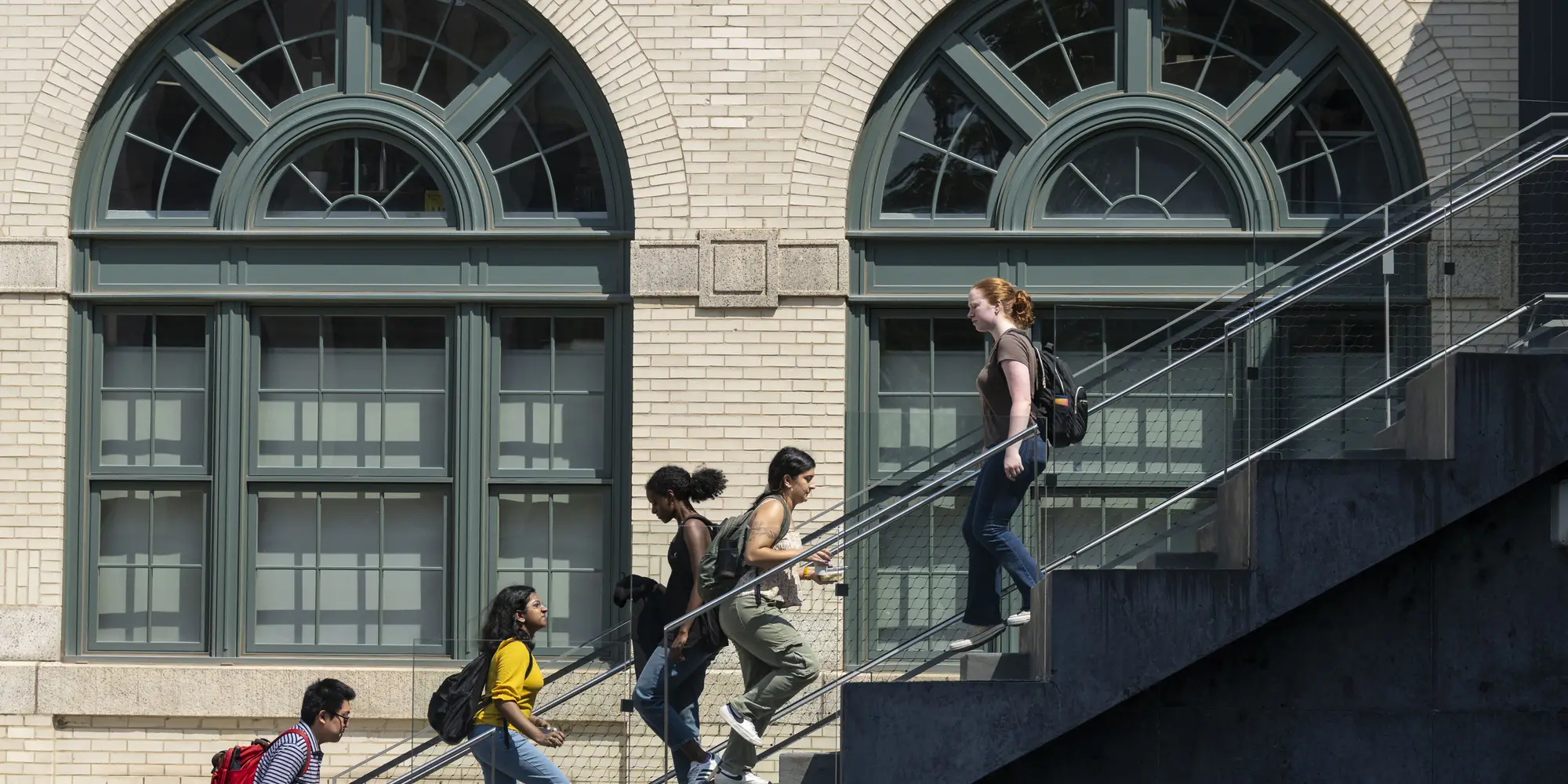 Students walk past a large set of windows on CMU campus.