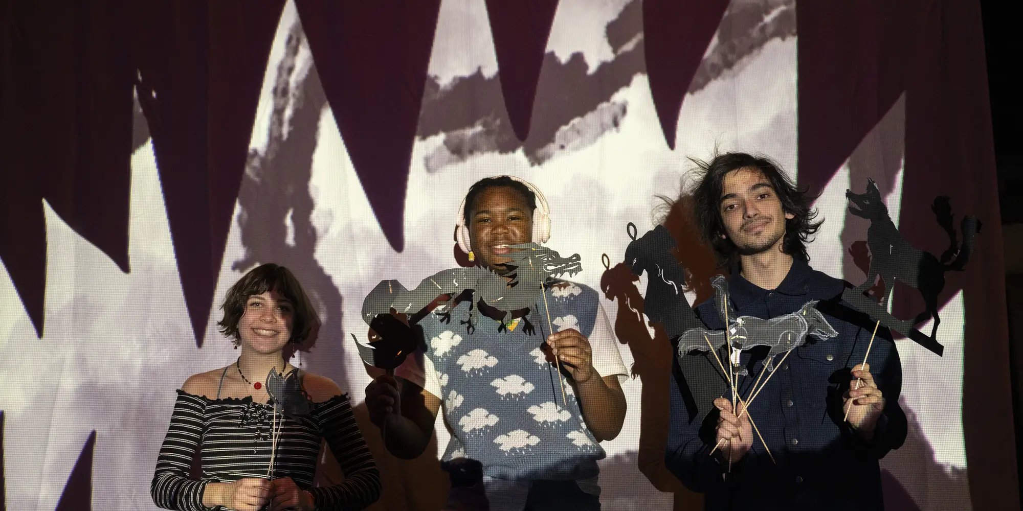 Students posing in the light of a projection.