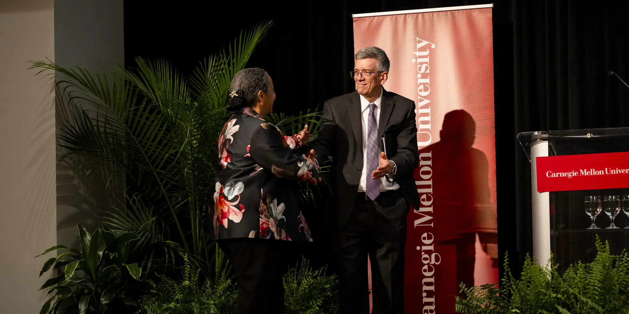 Provost Garrett exchanges greetings with Admiral Howard on stage