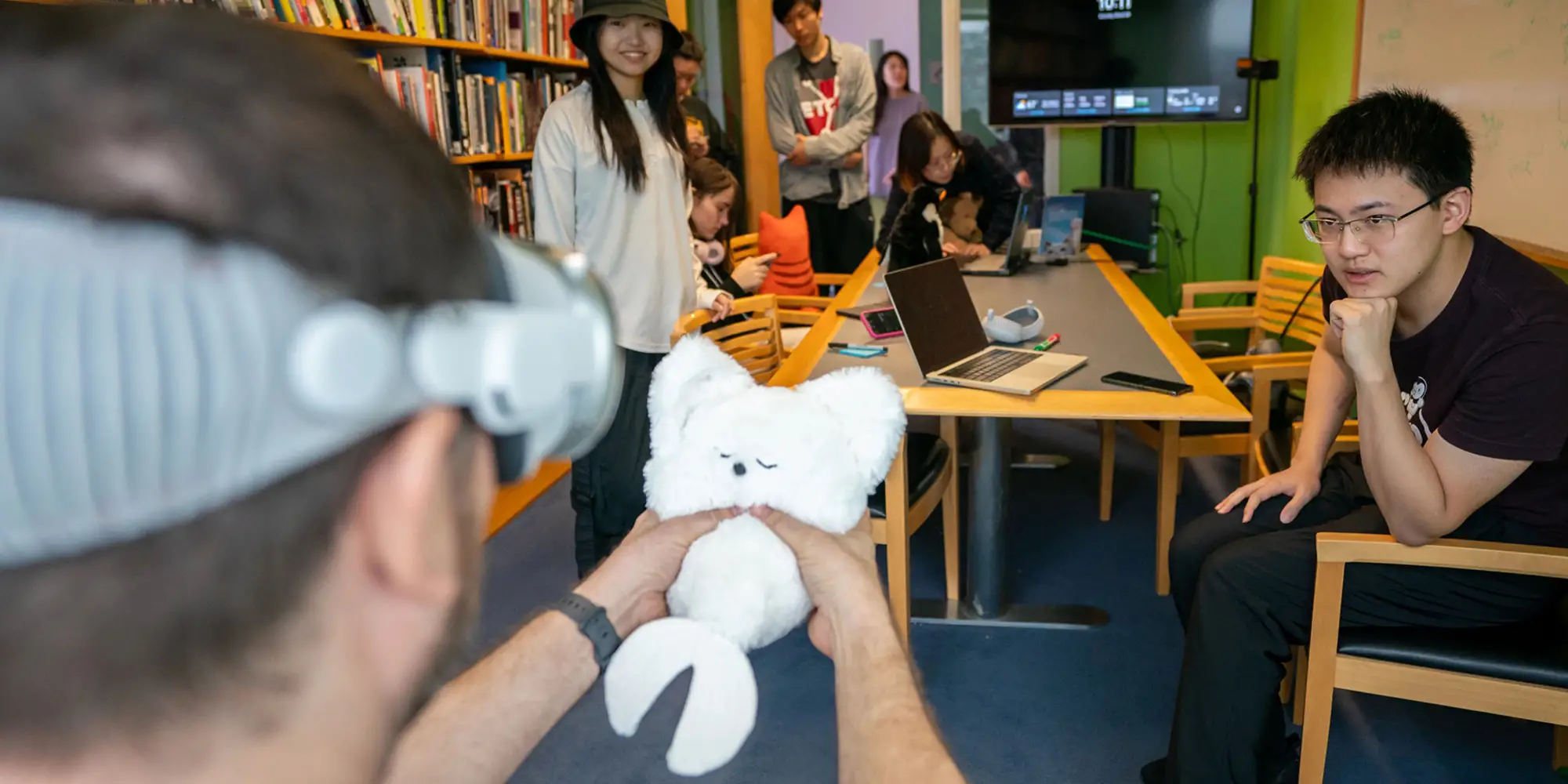 The Physical Presence Pet team looks on while a guest playtests their project.