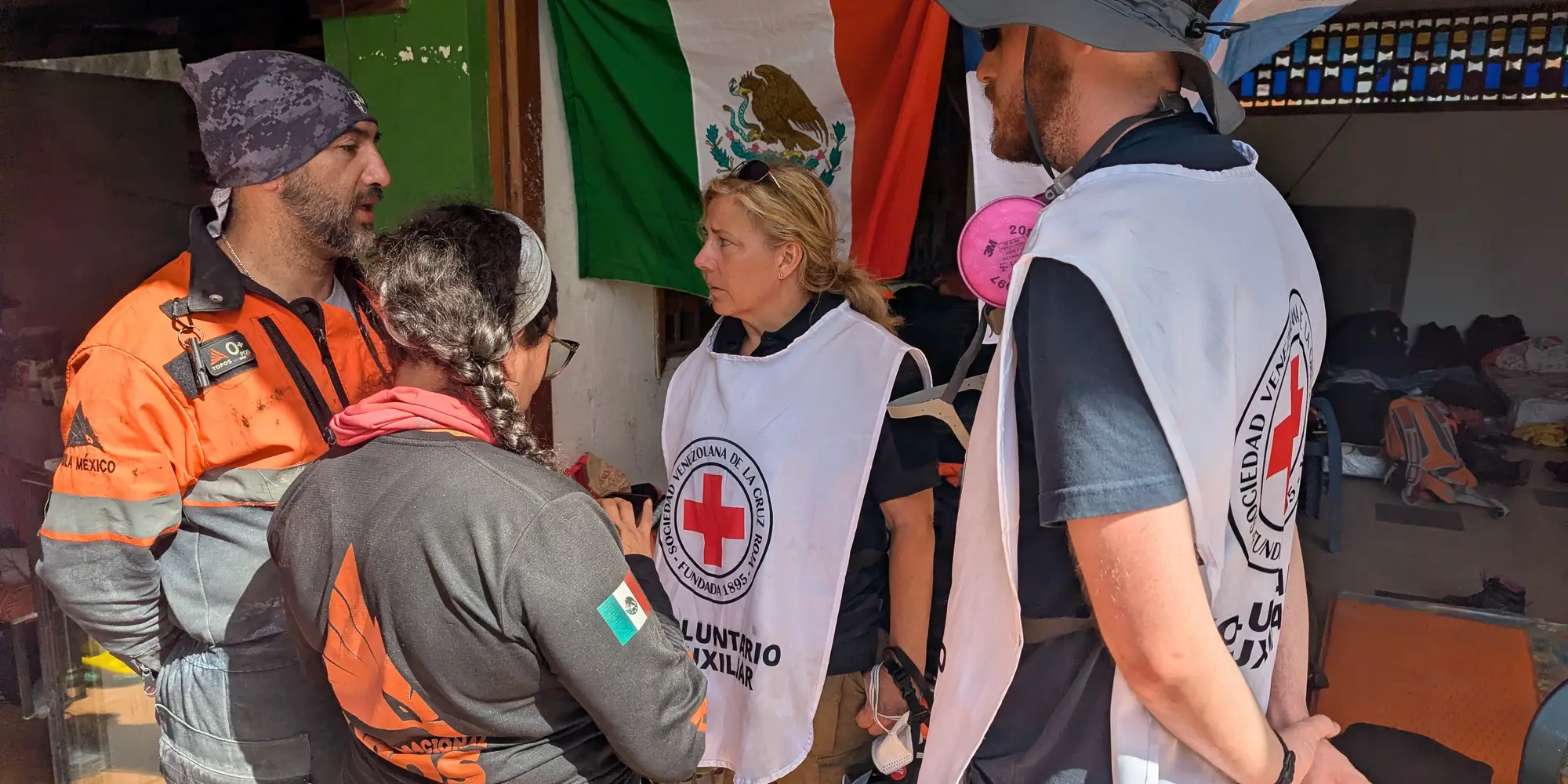 four people wearing rescue gear stand facing one another