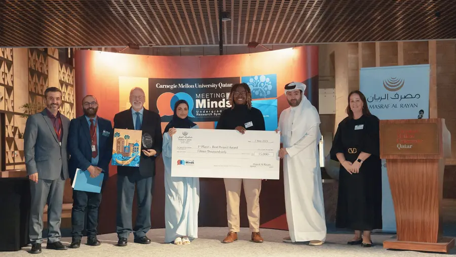 group of people on stage holding large check