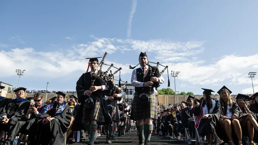 Bagpipers lead the procession.