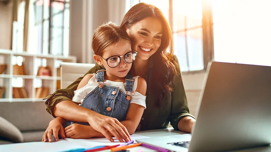 mother and daughter looking at laptop screen together