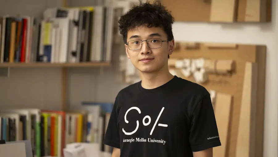 Andy Jiang wearing black SoA t-shirt inside classroom
