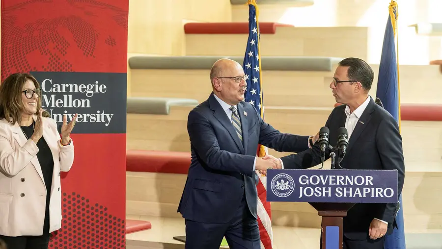 Farnam Jahanian shakes hands with Gov. Josh Shapiro