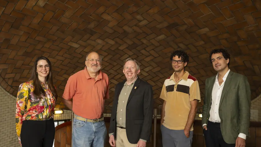 five people standing inside Baker Hall