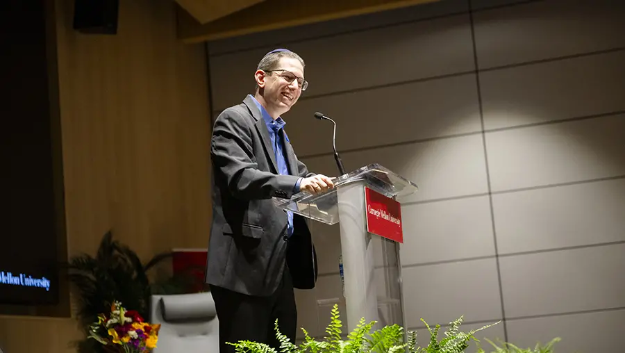 Rabbi Charlie Cytron-Walker standing at podium