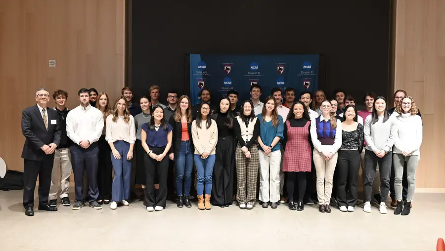 Jim Garrett standing with large group of student-athletes