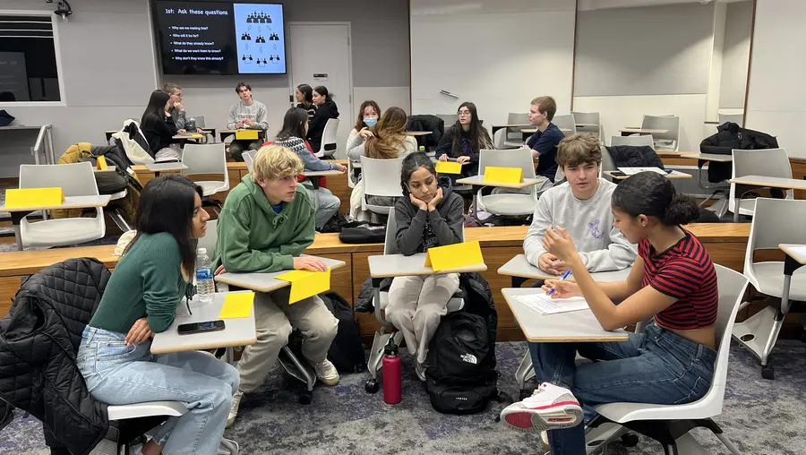 view of classroom focused on five students seated at their desks in a semicircle