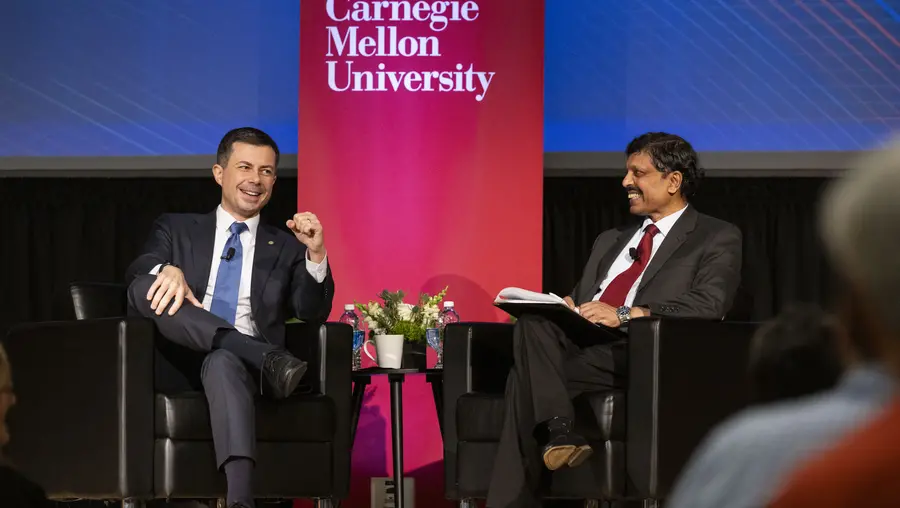 Pete Buttigieg and Raj Rajkumar talk during a Q&A.