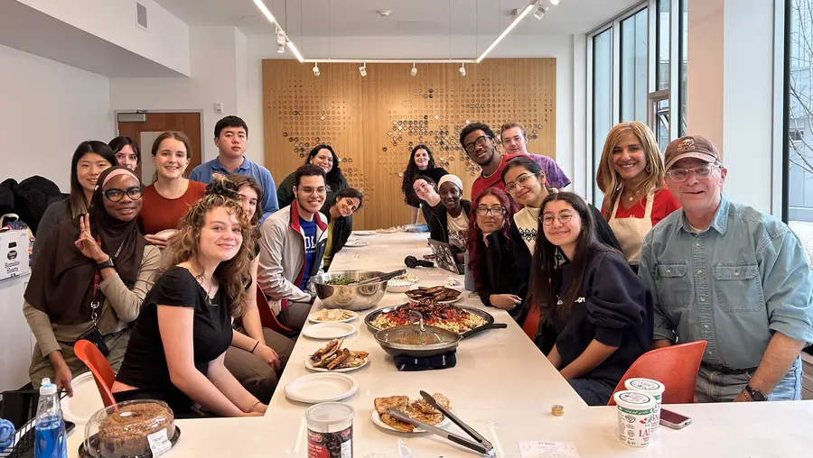 A group photo taken over cultural food prepared for Friendsgiving