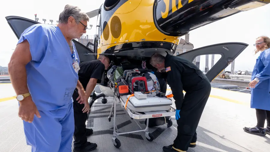 People load things into a helicopter.